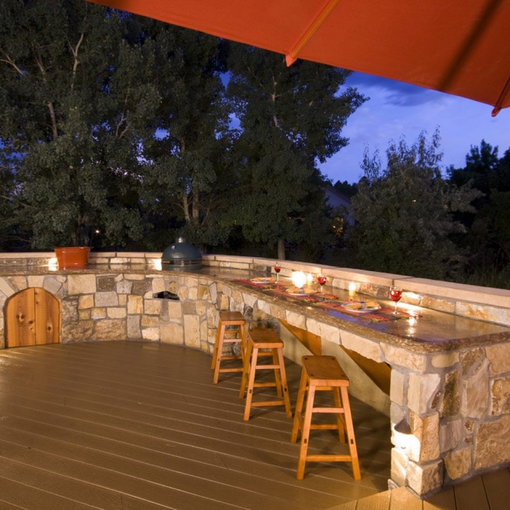 A backyard kitchen is integrated into the landscaping design.